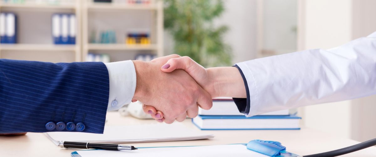 a buyer and seller of a medical practice shaking hands
