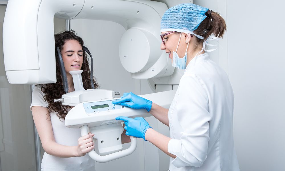 a dentist using an xray machine on a patient